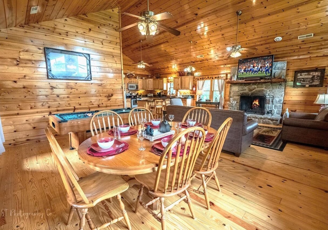 Gather around the rustic dining table for family meals in this warm, wood-paneled cabin. Enjoy cozy evenings by your stone fireplace with games, entertainment, and a fully-equipped kitchen nearby.