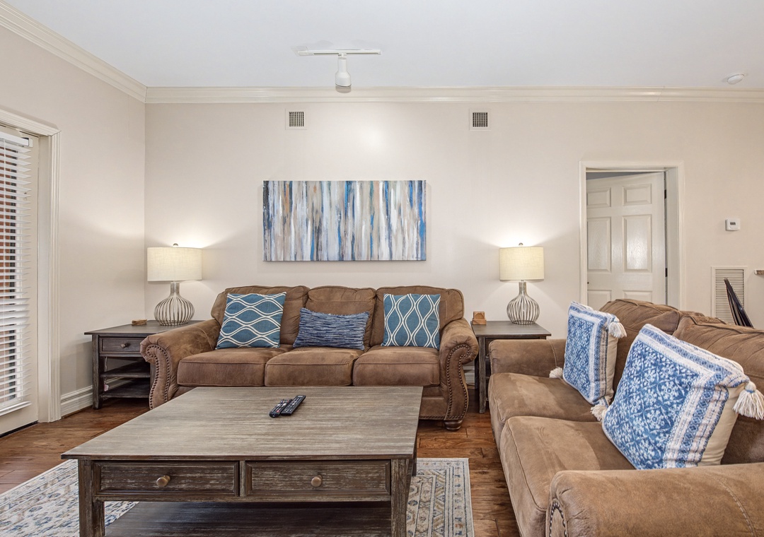 Sink into plush brown sofas with coastal blue accents in your bright, welcoming living room - perfect for movie nights.