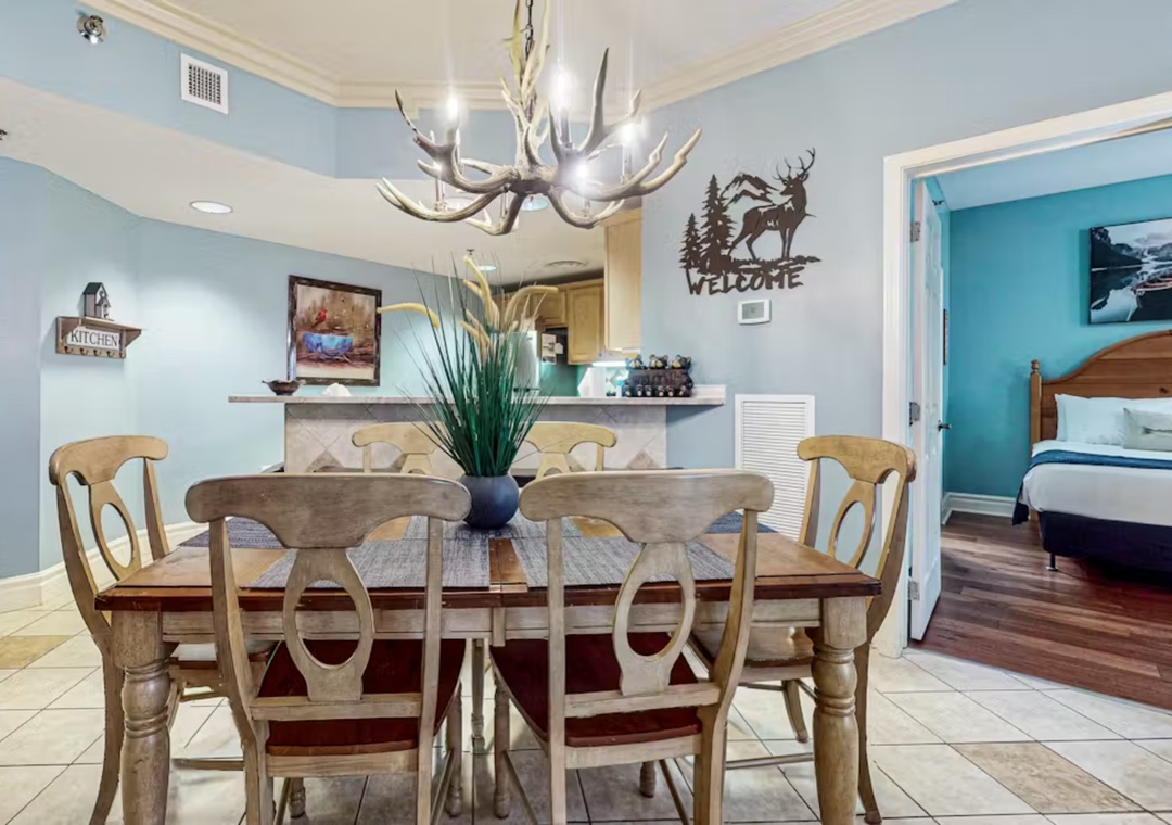 Gather around your rustic dining table beneath the striking antler chandelier, where mountain-inspired decor sets the perfect tone for memorable meals.