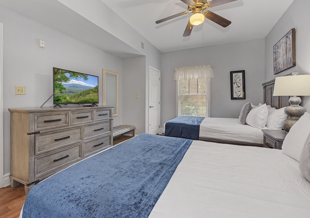 Unwind in your comfortable twin bedroom with plush linens, entertainment center, and peaceful mountain views from your window.