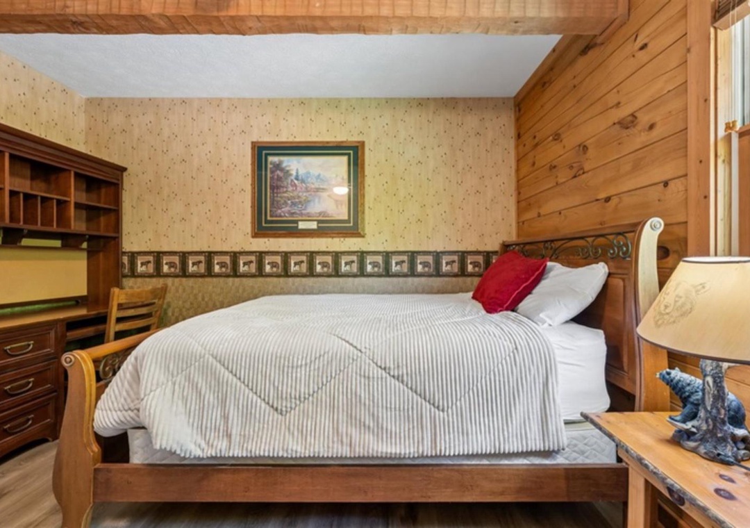 Unwind in this cozy bedroom where rustic wood paneling meets classic charm. Your restful retreat features a plush bed, warm lighting, and thoughtful touches that make you feel right at home.