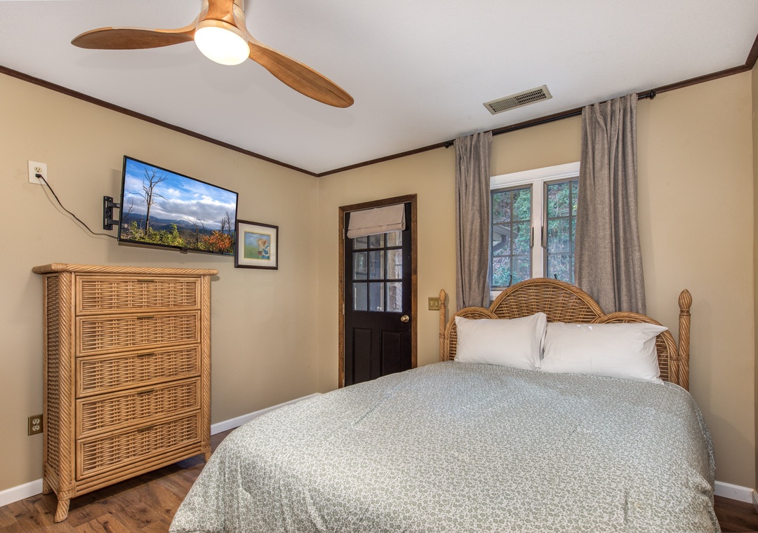 Unwind in your cozy bedroom with natural wicker furnishings, a ceiling fan for comfort, and entertainment at your fingertips.