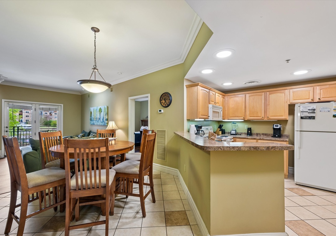 Your open-concept kitchen flows seamlessly into the dining area, perfect for preparing meals and gathering together in this bright, welcoming space.