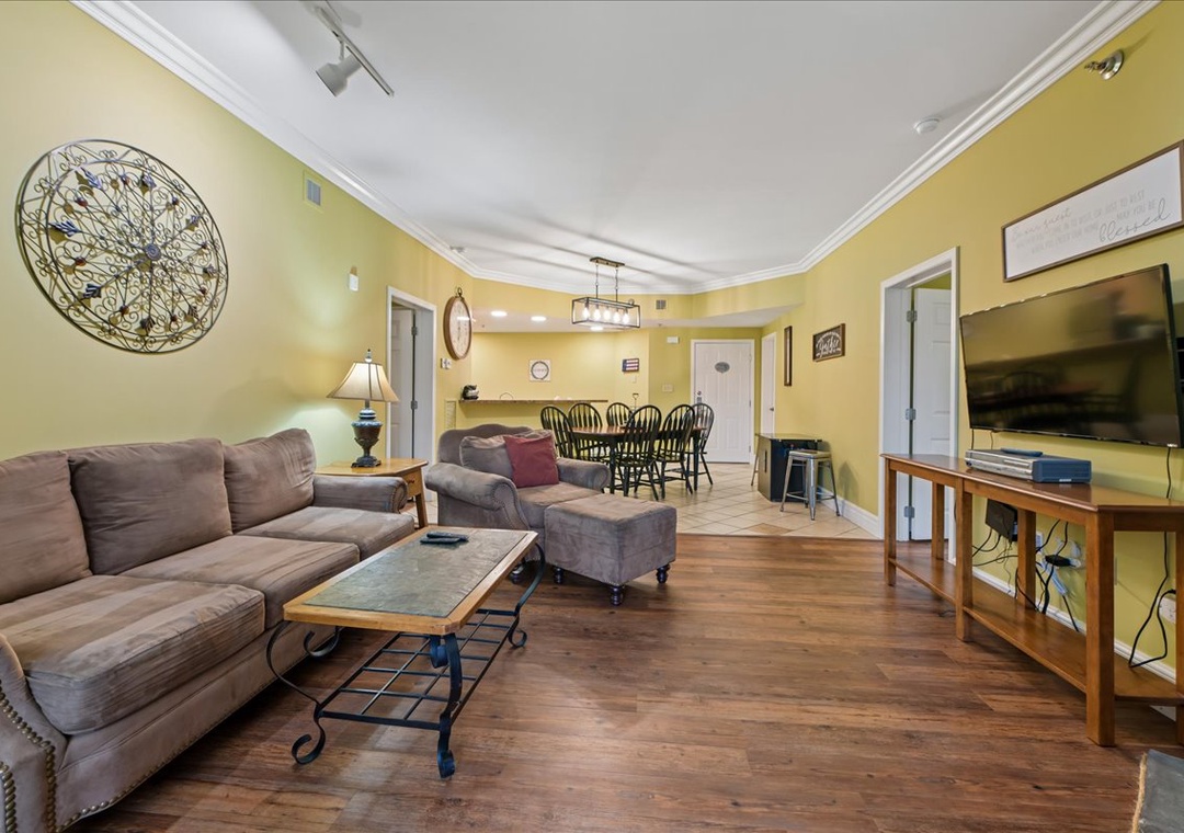 Sink into the plush sectional sofa and enjoy your favorite shows on the large flat-screen TV in this spacious open-concept living area.
