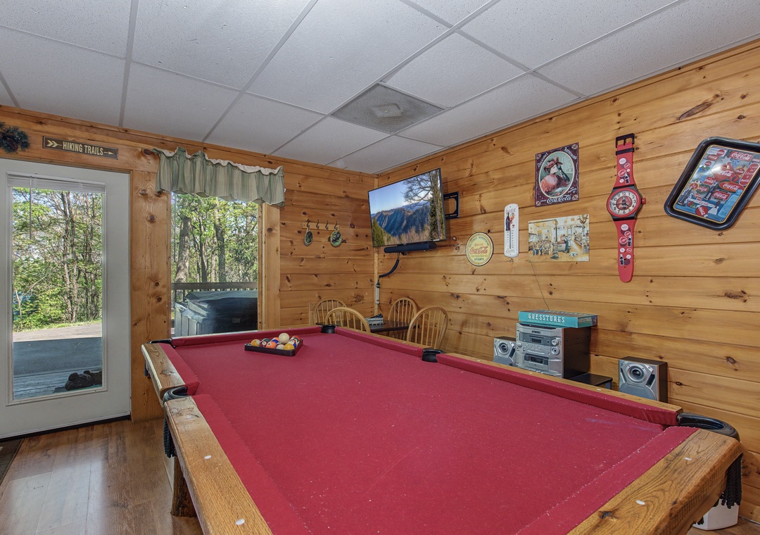 Challenge your friends to pool games in this cozy game room with rustic wood walls and mountain views.