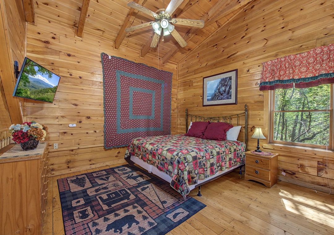 Relax in this cozy bedroom with rustic charm, featuring warm wood beams and forest views through your window.