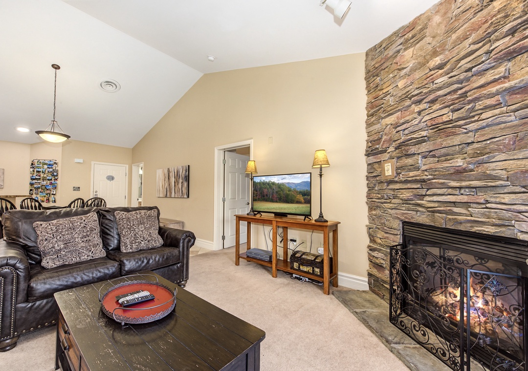 Cozy up by your stone fireplace while enjoying your favorite shows on the flat-screen TV in this inviting living room.