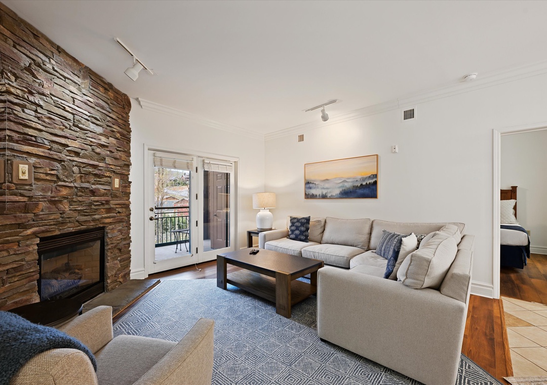 Unwind in your elegant living room with a cozy stone fireplace and comfortable sectional sofa.