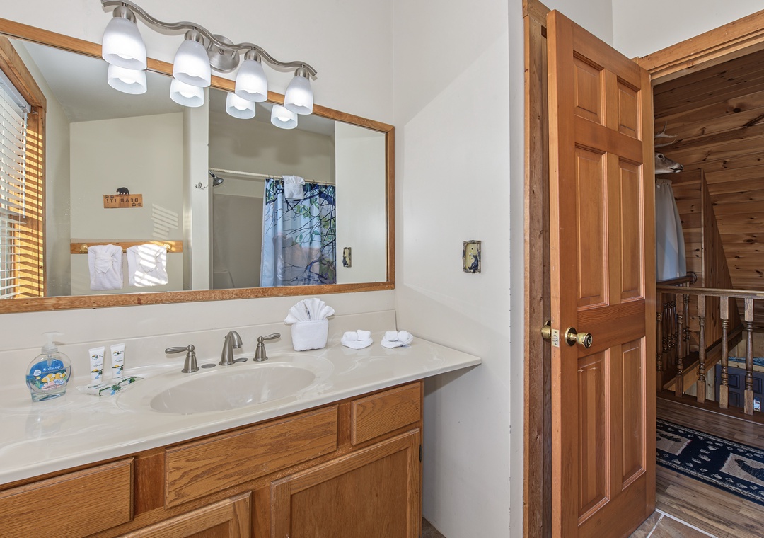 Step into your en-suite bathroom, where warm wood tones and thoughtful touches create a welcoming retreat. Fluffy towels await, and natural light filters through to brighten your morning routine.