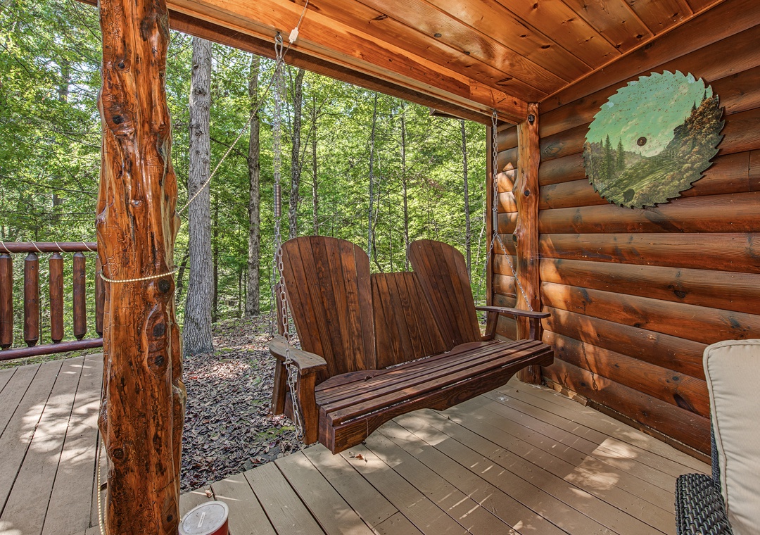 Settle into this charming swing on your private covered deck, surrounded by peaceful forest views. The rustic touches and handcrafted details add character to your outdoor retreat.