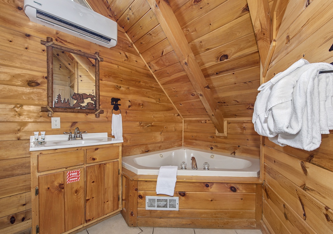 Soak in rustic comfort in your private wooden bathroom, complete with jetted tub and mountain lodge charm.