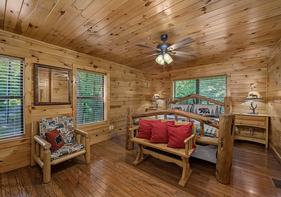 Unwind in this inviting bedroom with rustic wood paneling and handcrafted log furniture. Cozy lamps and a gentle ceiling fan create the perfect retreat after your mountain adventures.