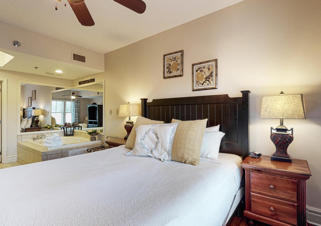 Unwind in your elegant bedroom featuring a king bed and romantic jetted tub, perfect for relaxing after exploring nearby attractions.