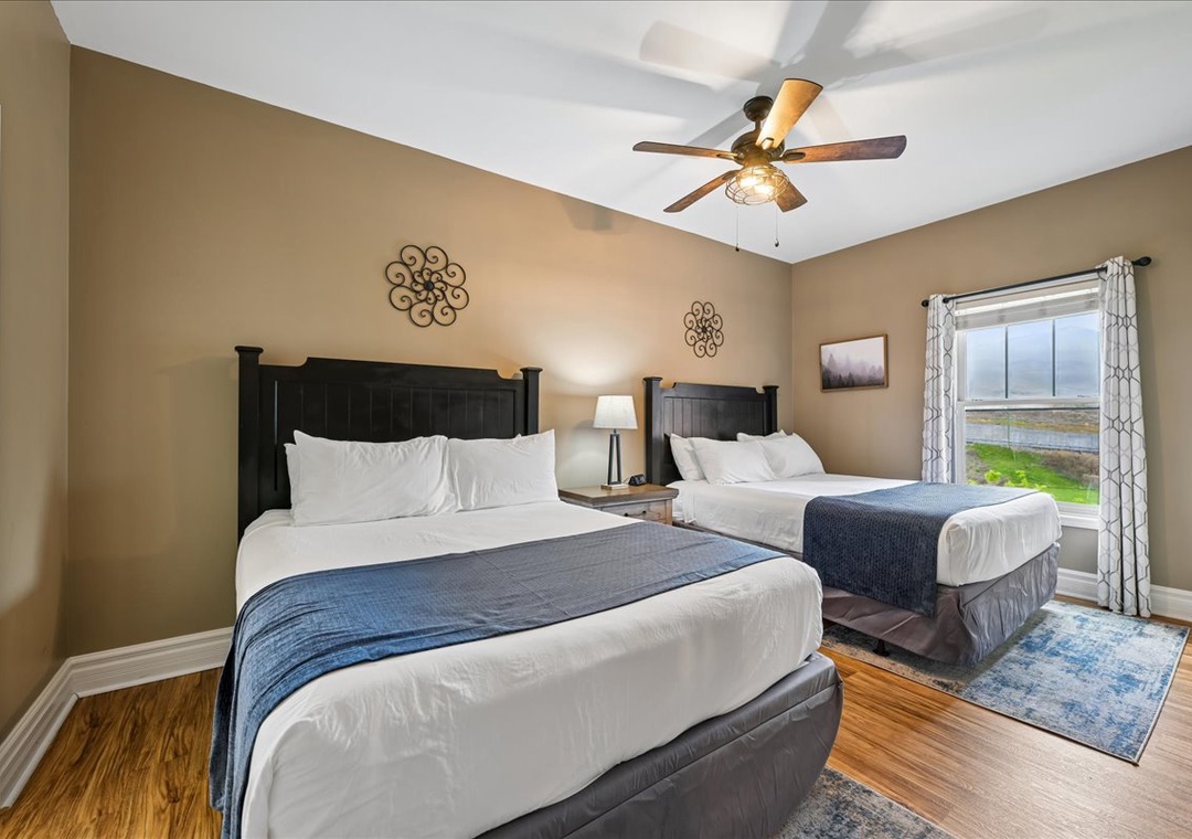 Drift off peacefully in this cozy twin bedroom with plush linens, warm lighting, and serene views of the surrounding landscape.