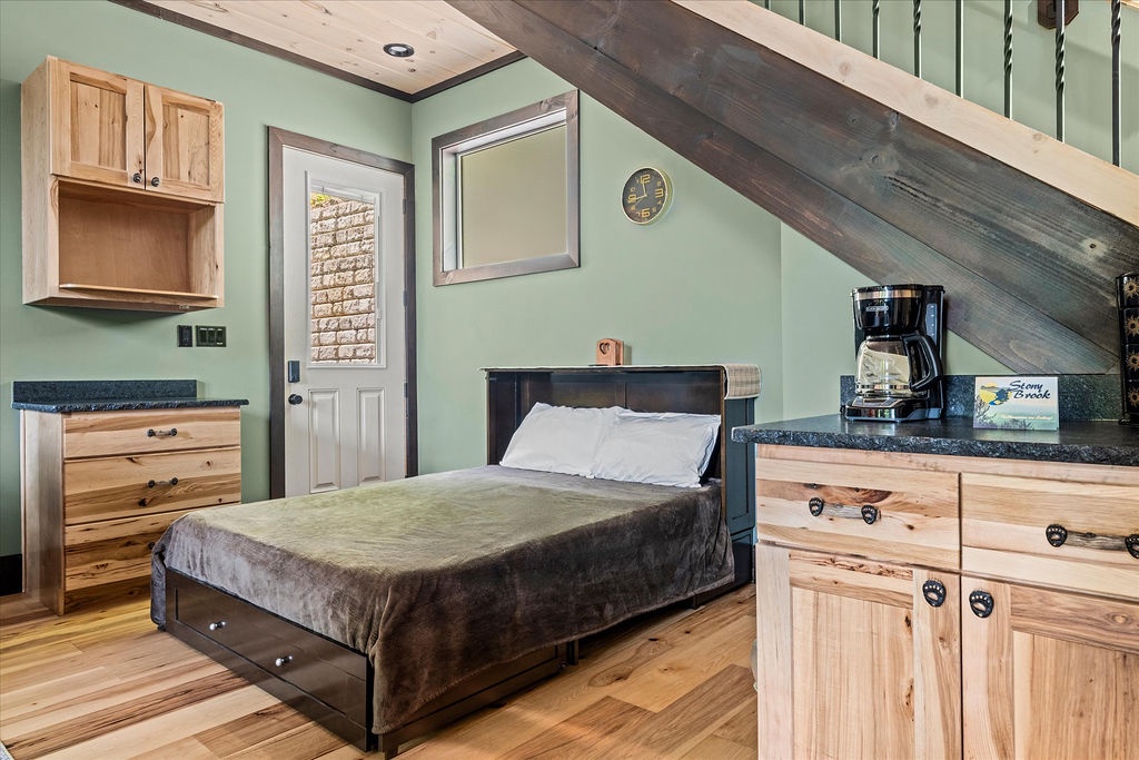 Your cozy retreat blends rustic charm with modern convenience, featuring warm wood tones, vaulted ceilings, and a comfortable sleeping space with thoughtful amenities nearby.