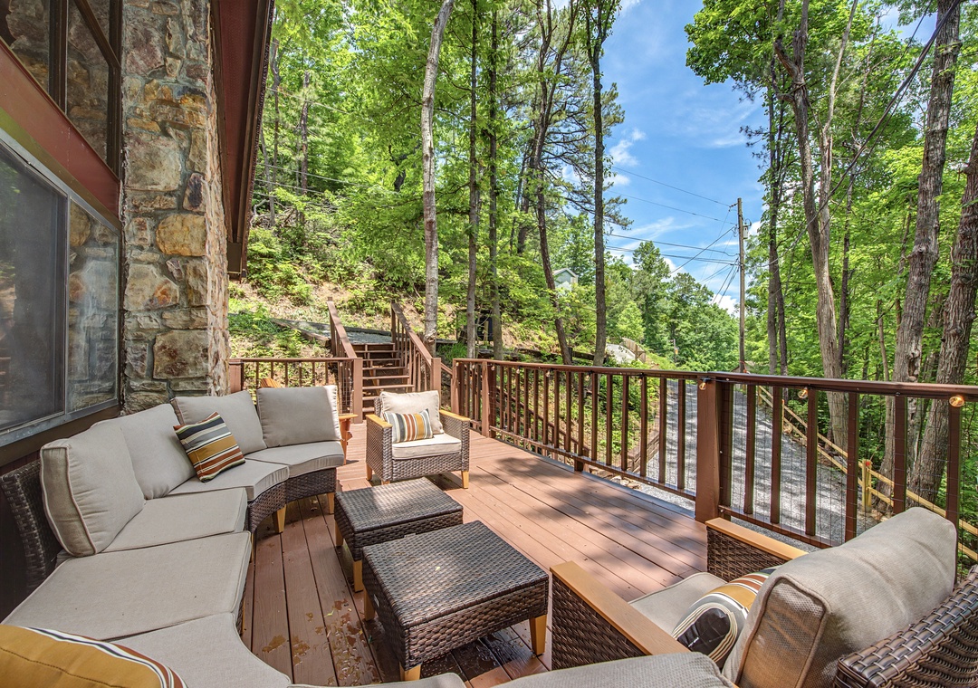 Your spacious private deck overlooks lush forest, offering plush seating, cool shade, and the perfect retreat for morning coffee or evening relaxation among the trees.