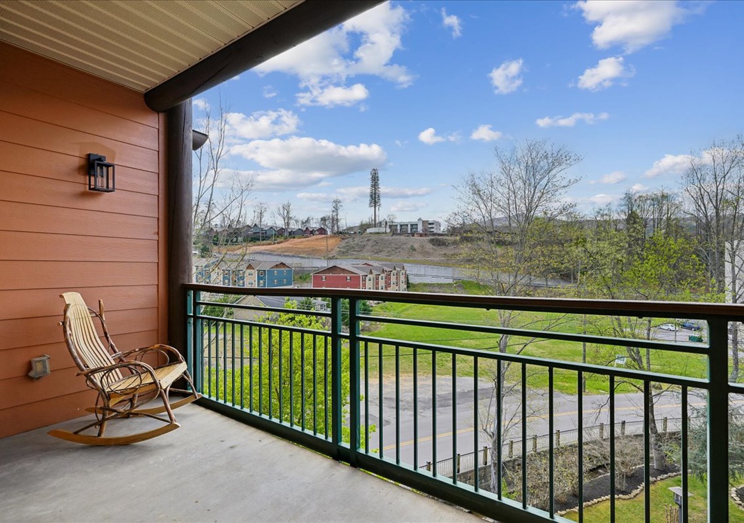 Relax in your private rocking chair while taking in peaceful views of green spaces and colorful neighborhood buildings below.