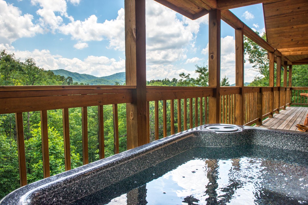 Sink into your private hot tub on the covered deck and let the stunning mountain views melt away all your worries beneath soft clouds and blue sky.
