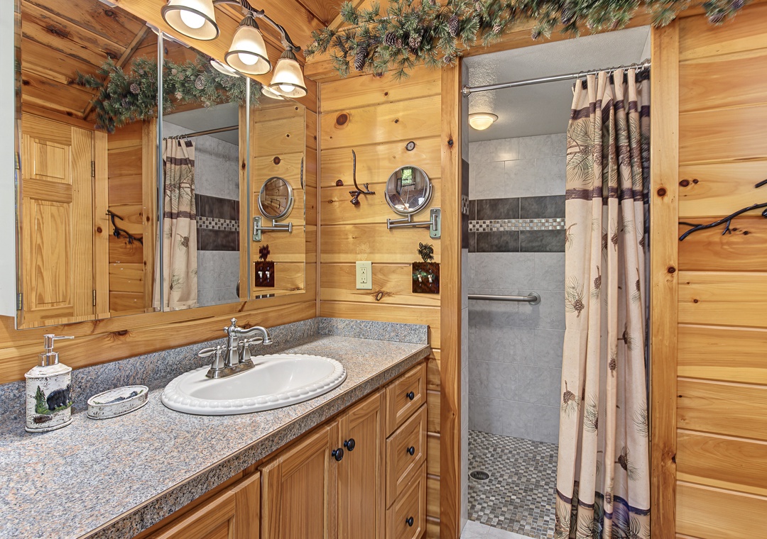 Step into your private bathroom, where rustic pine warmth meets modern comfort—a spacious walk-in shower awaits after your mountain adventures.