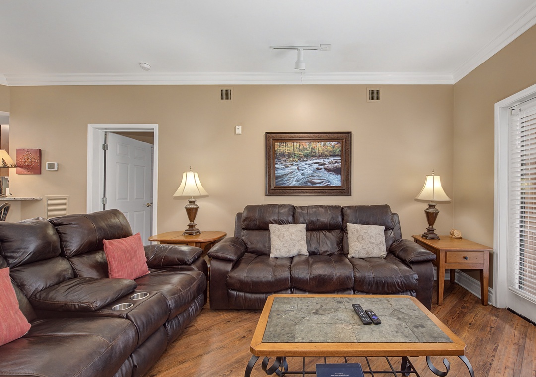 Sink into plush leather recliners in your cozy living room, where warm lighting and rustic artwork create the perfect atmosphere for movie nights.