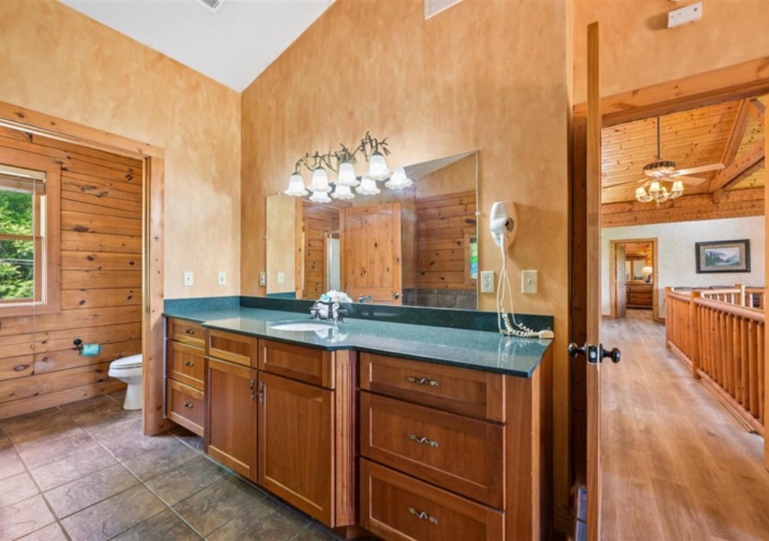 Freshen up at your spacious dual-sink vanity with warm lighting and plenty of storage, perfectly positioned for easy access from both bedroom and bath.