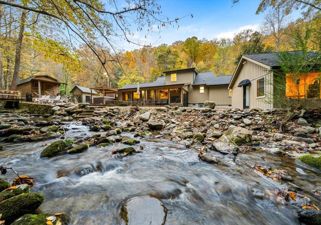 A tranquil riverside retreat nestled among autumn foliage, where the gentle rush of the creek creates a serene backdrop for your mountain escape.