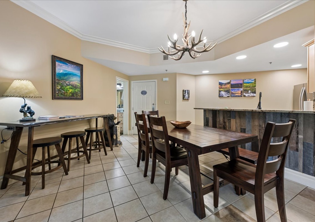 Gather around the rustic dining table for memorable meals, with a cozy fireplace and mountain artwork creating the perfect atmosphere for your stay.