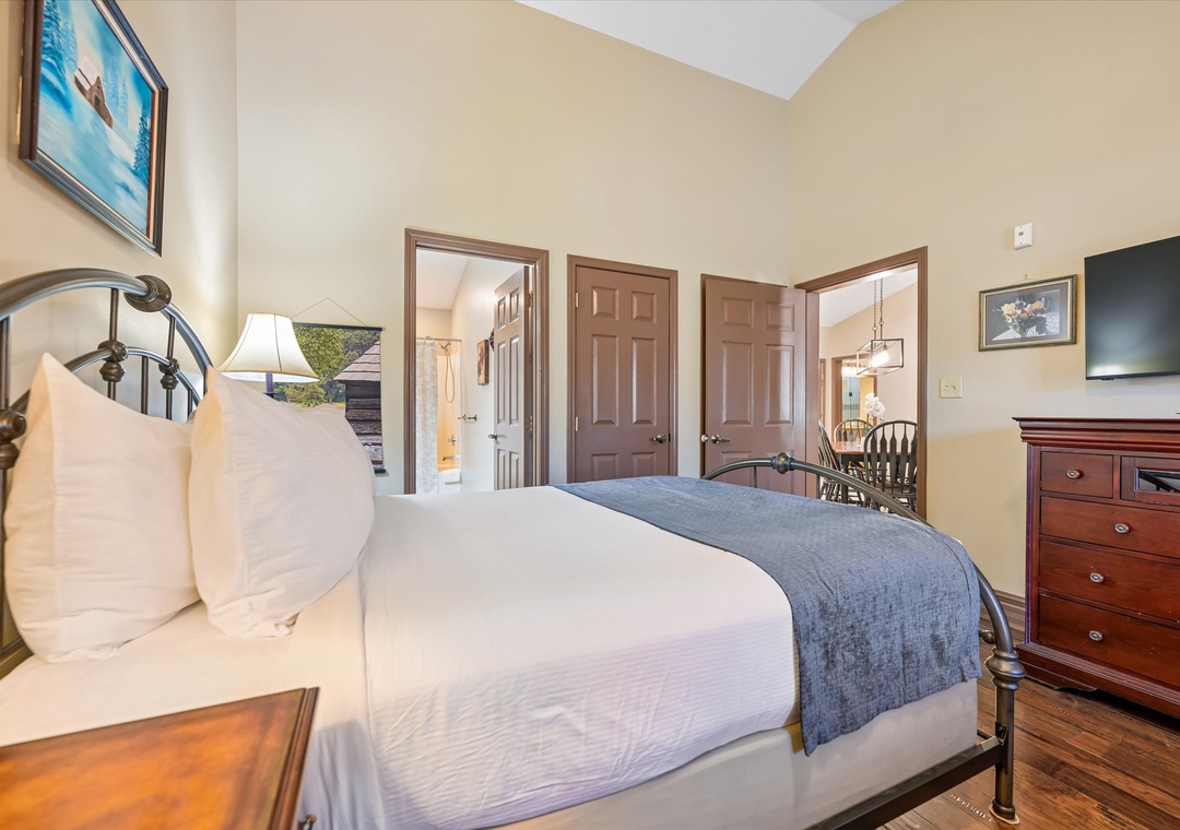 Sink into crisp white linens and rest your head on plush pillows in your cozy bedroom retreat with warm wood floors and classic furnishings.