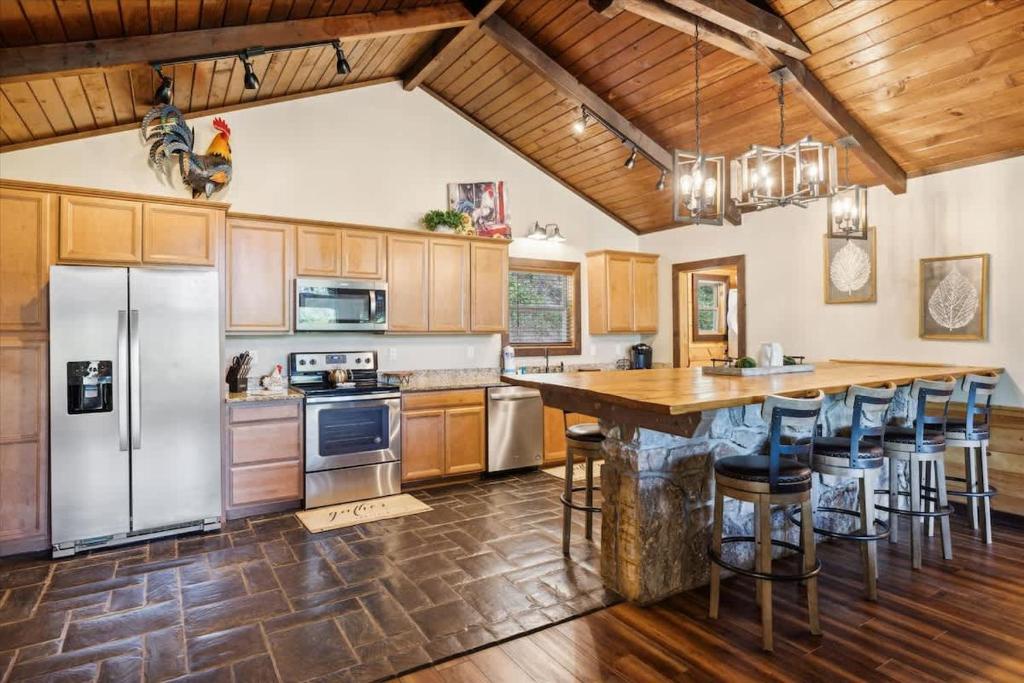 Picture yourself preparing meals in this stunning open kitchen with vaulted wood ceilings, modern stainless appliances, and a rustic island bar where everyone gathers for conversation and morning coffee.