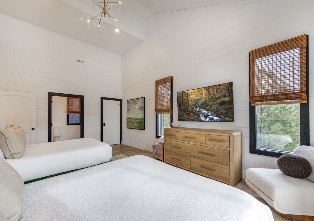 Sink into crisp white linens while natural light streams through bamboo blinds, creating your perfect retreat with mountain views.