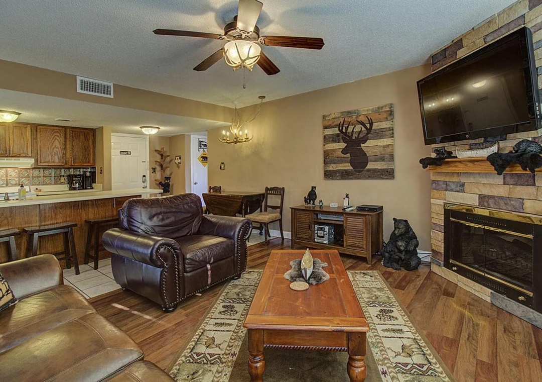 Relax in your rustic retreat with leather seating, stone fireplace, and mountain-themed decor creating the perfect cozy atmosphere.