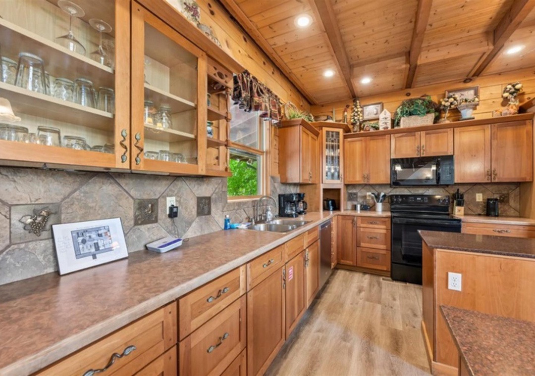 Your fully equipped kitchen features warm wood cabinetry, granite countertops, modern appliances, and rustic vaulted ceilings—perfect for preparing home-cooked meals and gathering with loved ones.
