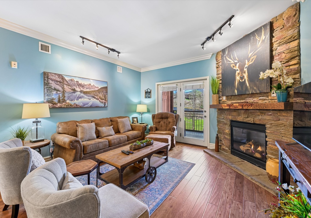 Cozy up by the stone fireplace in your welcoming living room, where leather seating and rustic charm create the perfect mountain retreat atmosphere.