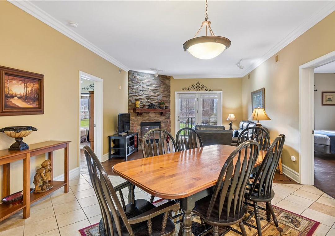 Gather around your warm dining table, where the stone fireplace creates perfect ambiance for memorable meals together.