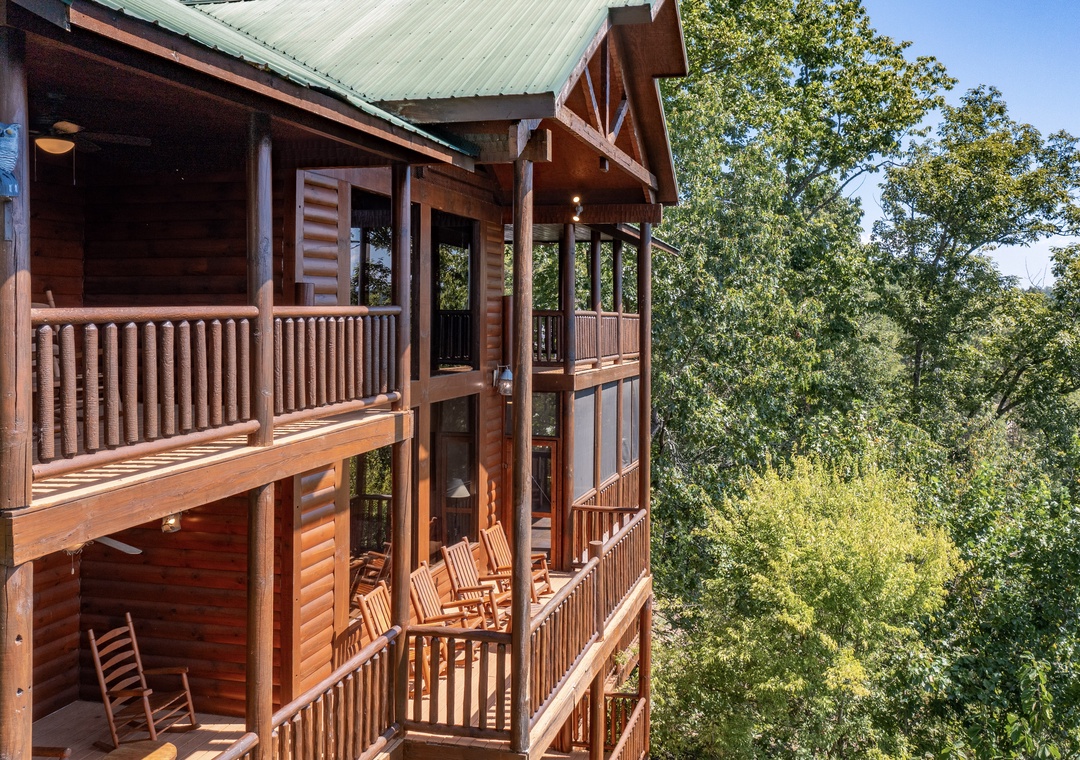 A multi-level log cabin retreat surrounded by lush forest, featuring two spacious private balconies with rocking chairs where you can unwind and take in the peaceful wooded scenery.