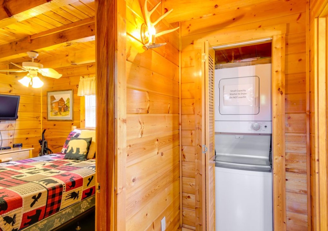 Your cozy cabin features rustic charm with warm wood walls, comfortable bedding, and convenient in-room laundry facilities for extended stays.