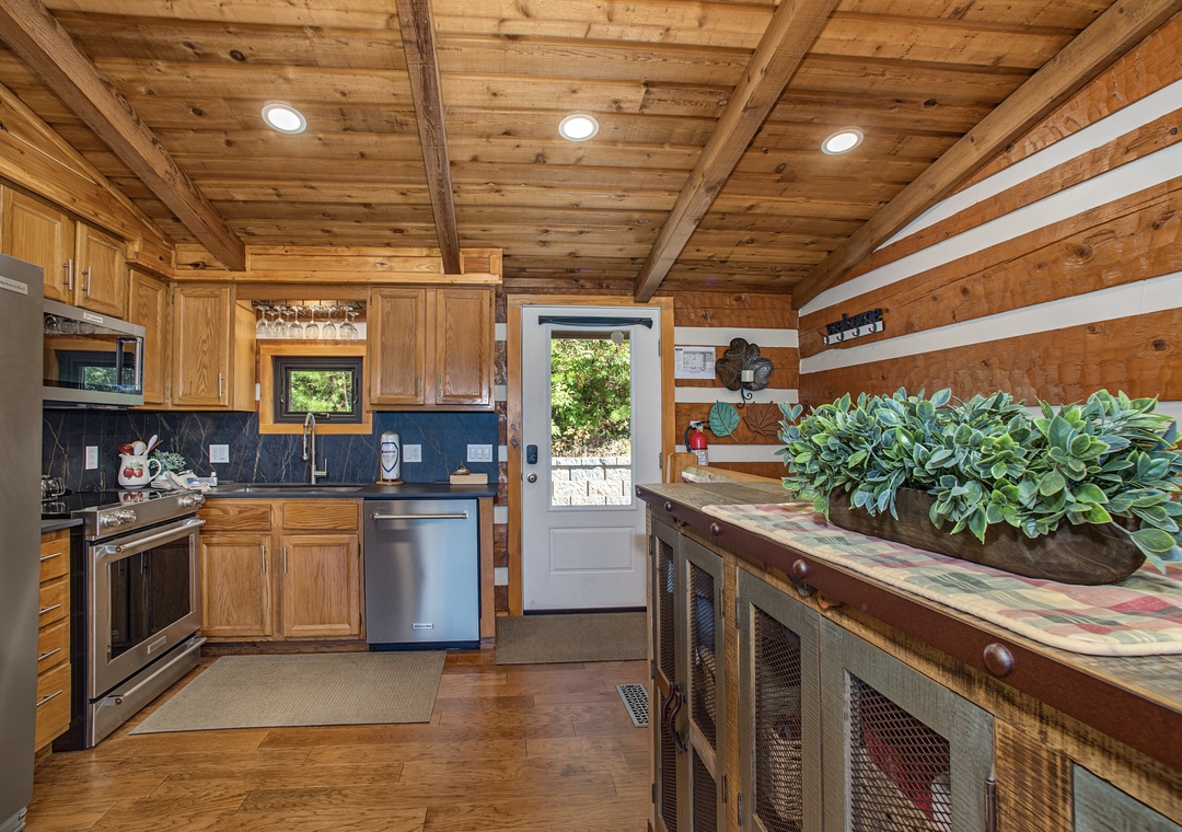 Step into your rustic-chic kitchen, where warm wood beams and custom cabinetry create a cozy mountain retreat. Modern appliances meet timeless charm, giving you everything you need to whip up memorable meals during your stay.