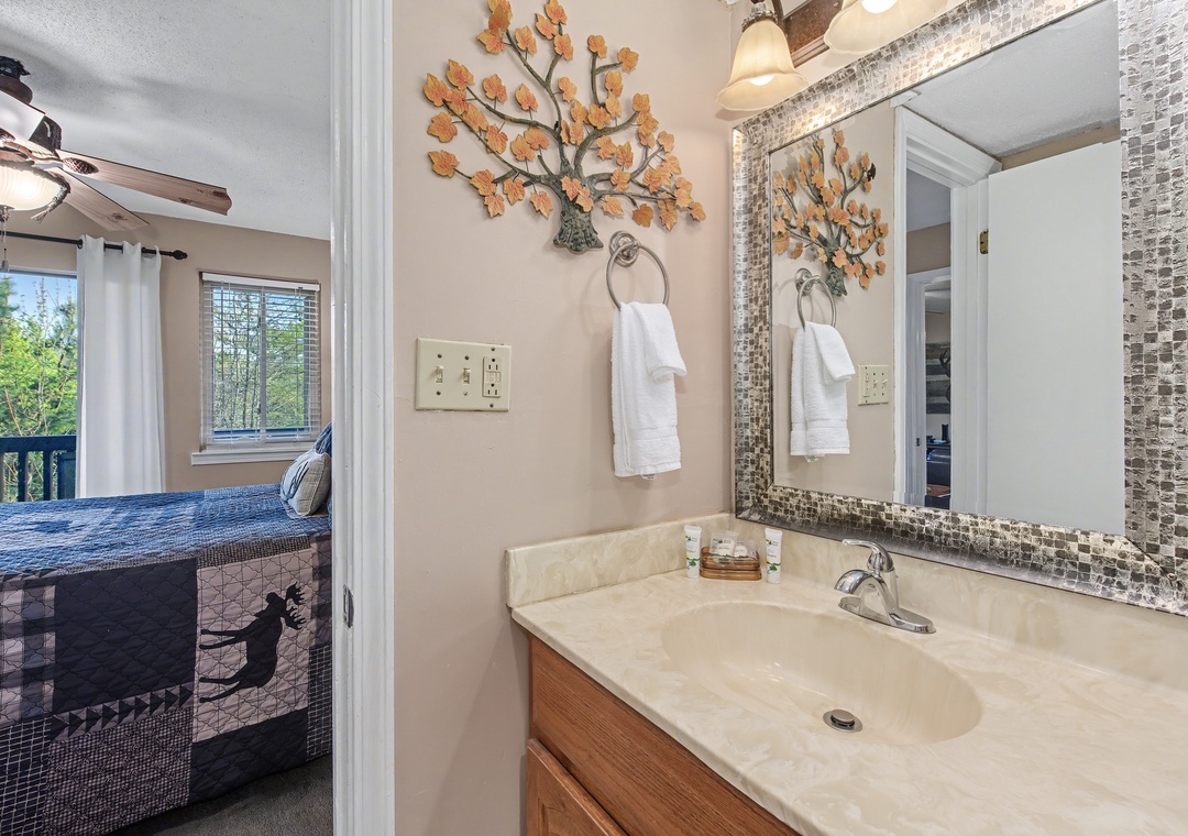 Your bathroom features stunning mosaic tile accents, decorative leaf details, and fresh towels ready for your stay.
