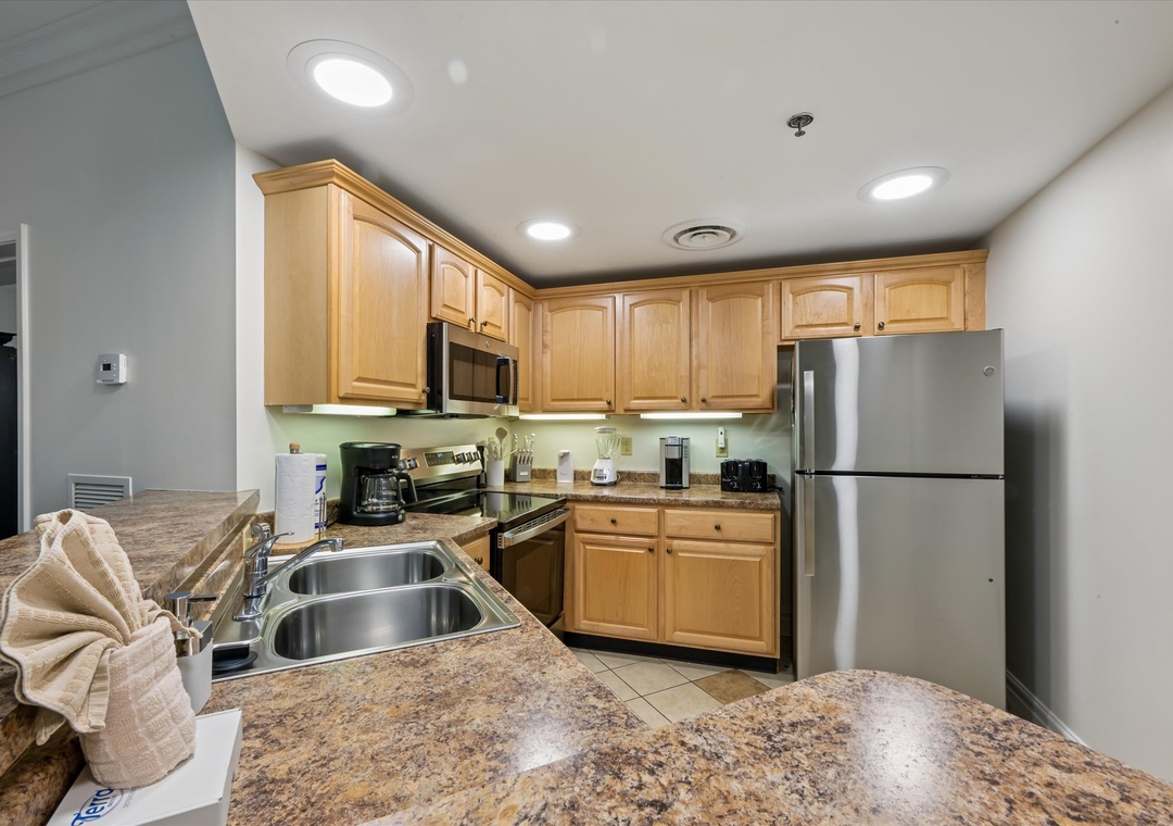 Your fully equipped kitchen features granite countertops, stainless steel appliances, and warm wood cabinetry for all your home cooking needs.