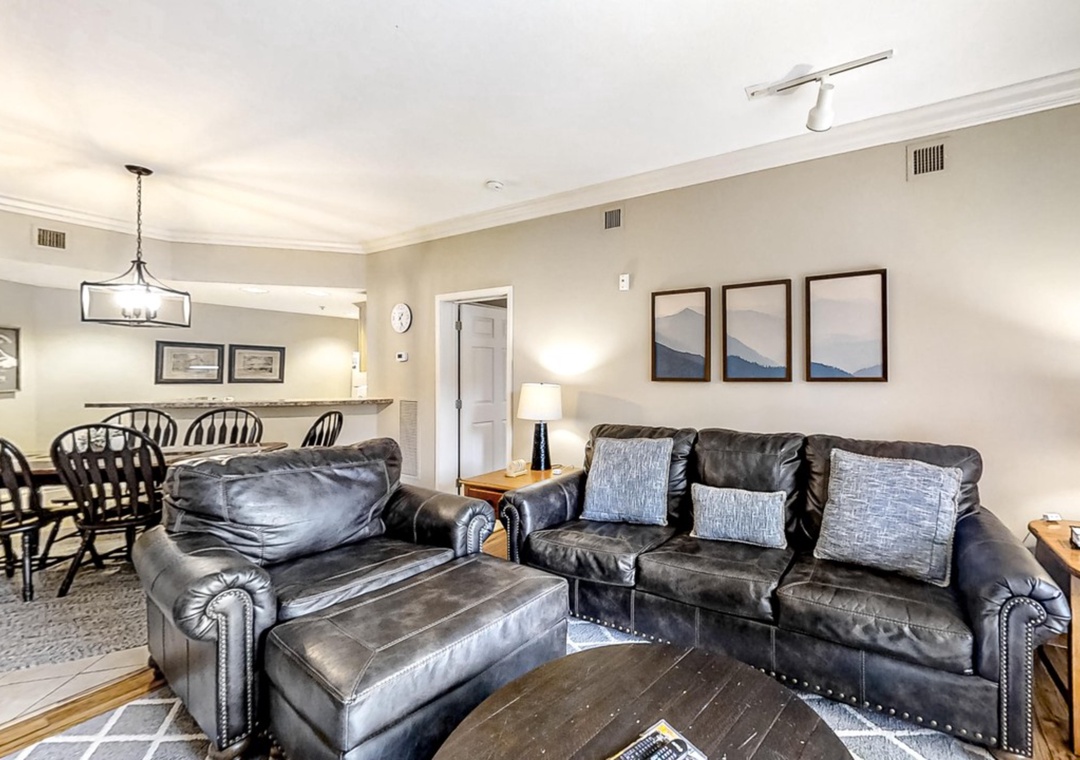 Sink into plush leather sofas in your spacious living area, where mountain artwork and warm lighting create the perfect atmosphere for relaxing after your adventures.