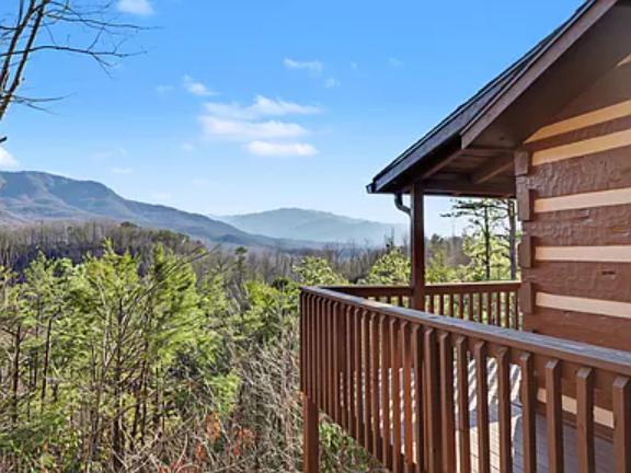 Sweeping mountain views and lush forest surround the property, offering a peaceful retreat in nature's embrace. The balcony provides an ideal spot to enjoy the scenic landscape.