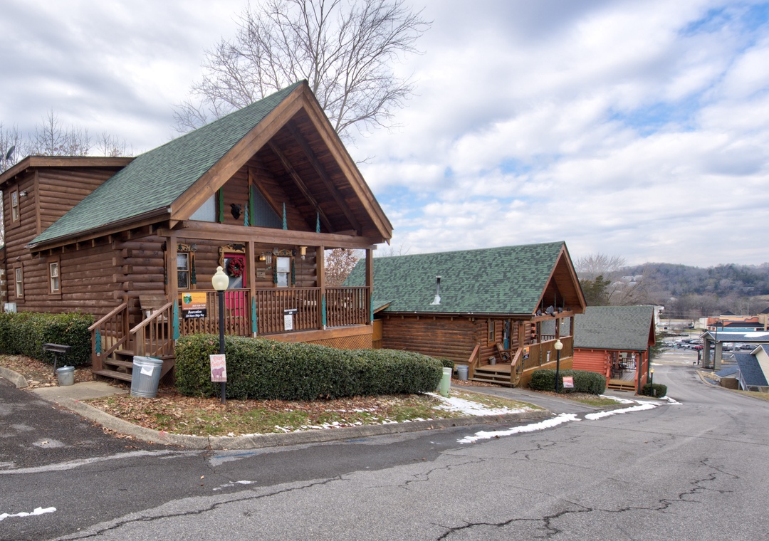 Rustic log cabin rental with covered porches and mountain views, nestled in a scenic area with convenient parking.