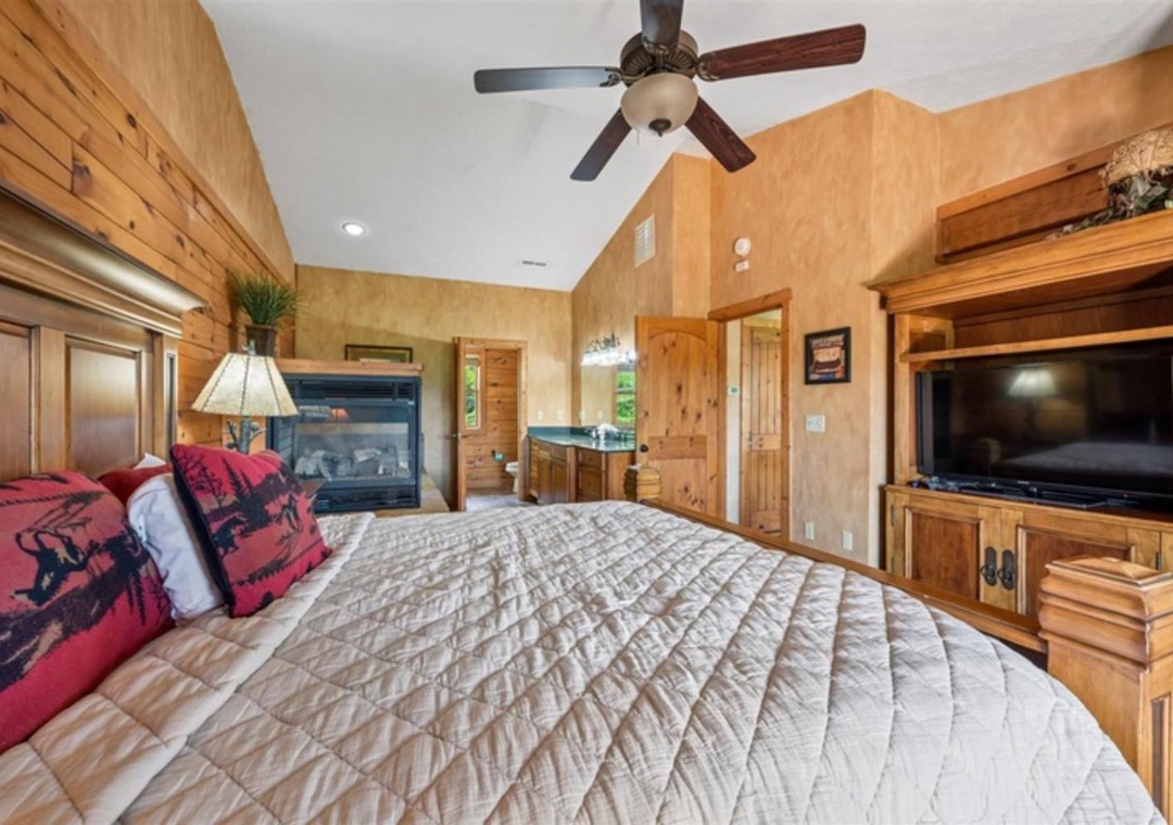 Sink into the plush quilted bedding and enjoy your private suite featuring a cozy fireplace, ceiling fan, and entertainment center. The warm wood accents and spacious layout create your perfect mountain retreat.