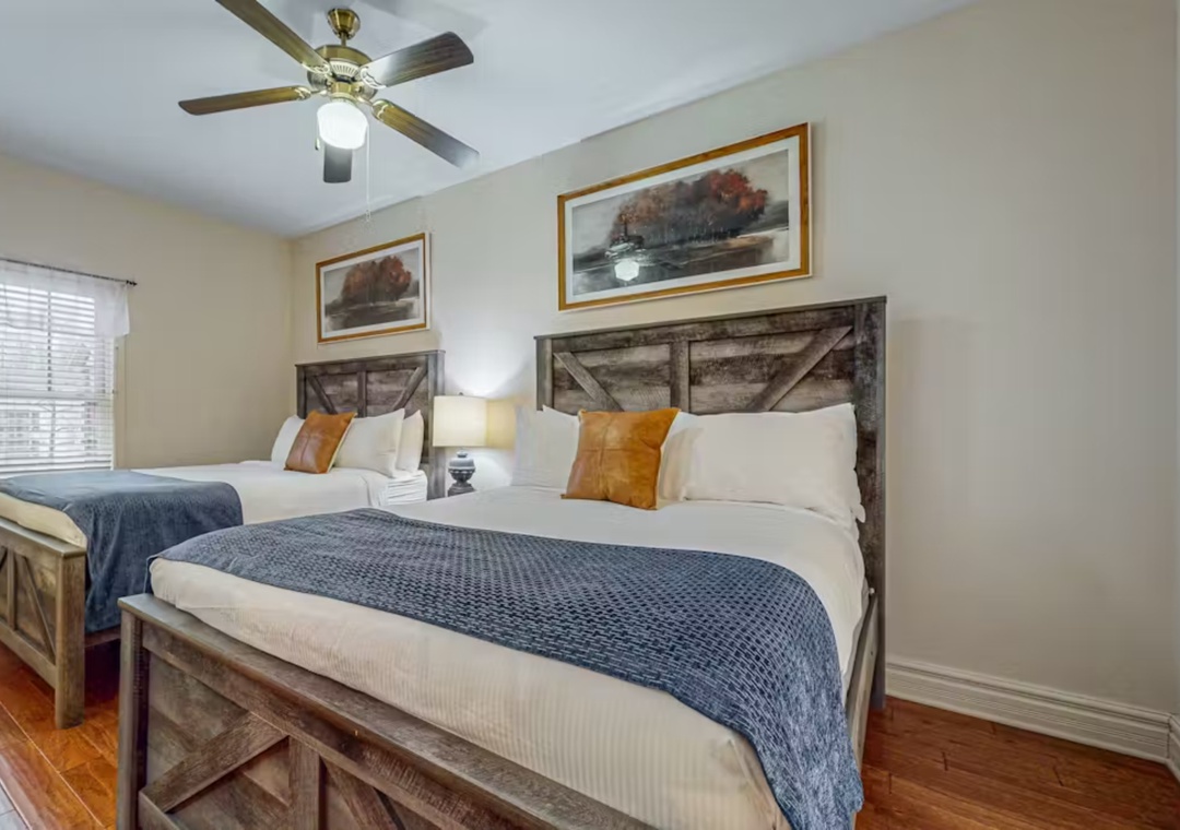 Relax in rustic comfort with twin beds dressed in crisp linens and cozy blue throws, perfect for peaceful nights.