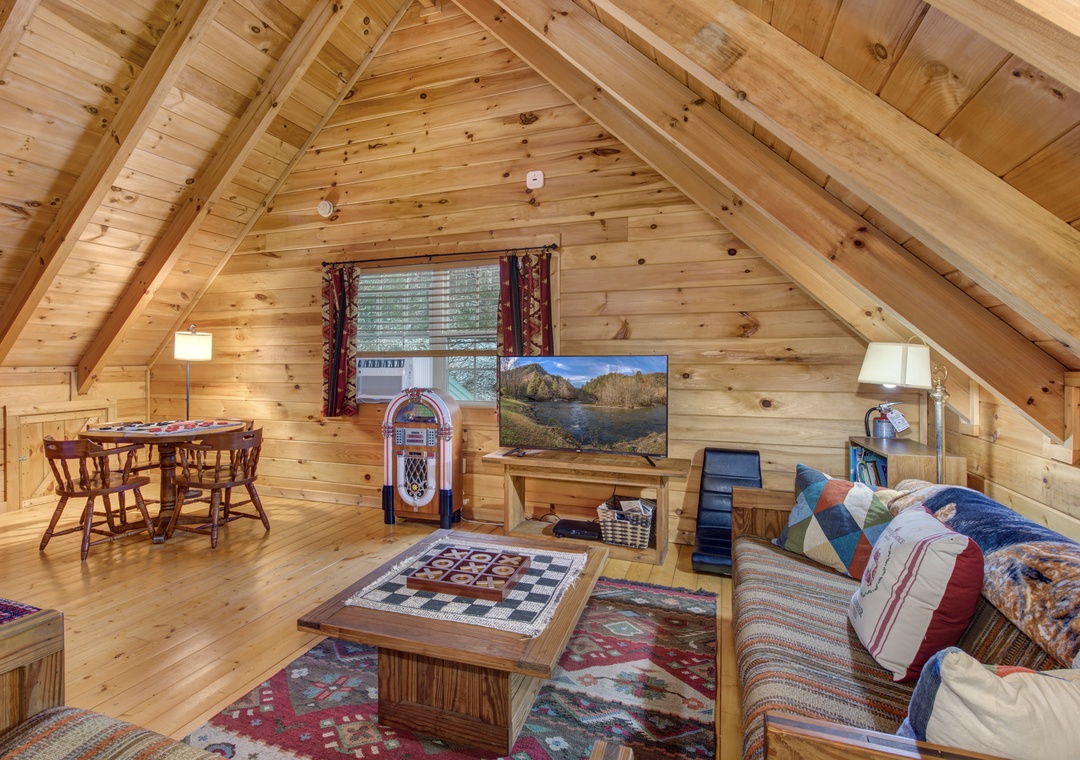 Unwind in your cozy loft with vaulted wood ceilings, comfy seating, and classic games for memorable evenings.