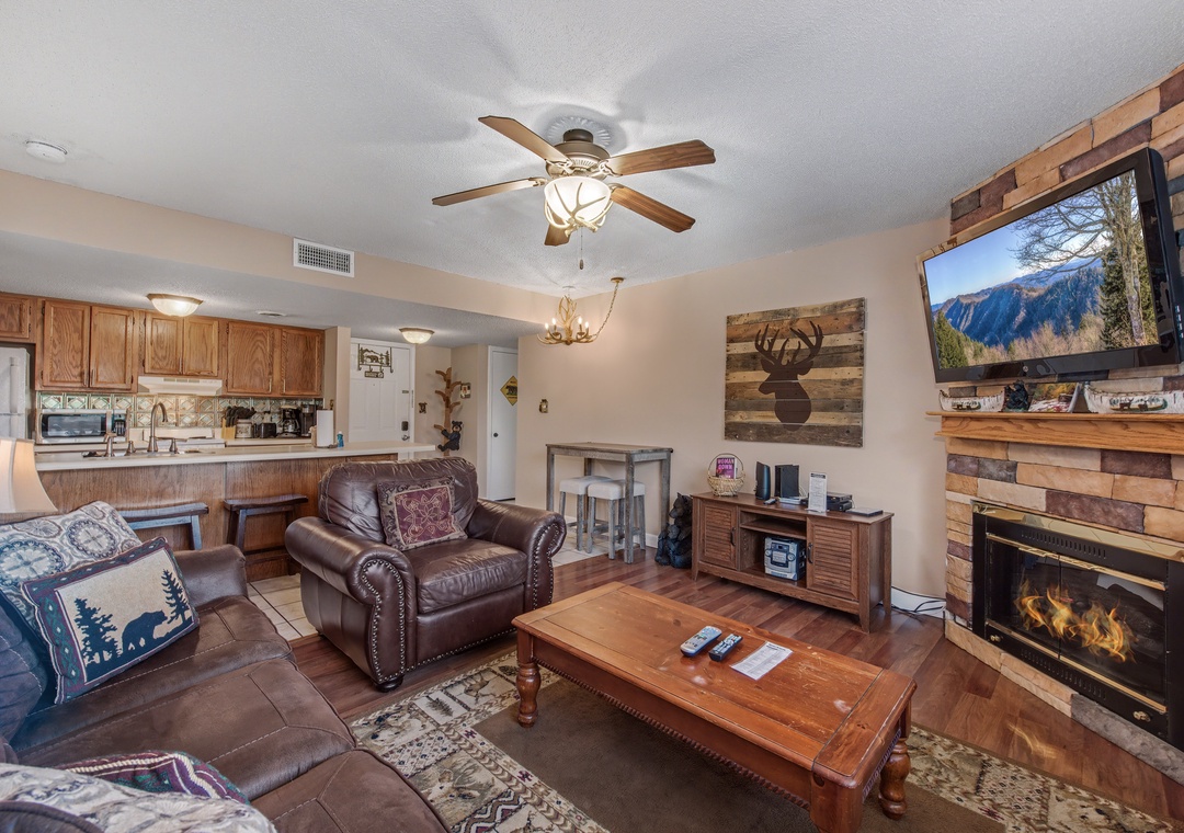 Unwind in your cozy living space featuring rustic wood accents, a crackling fireplace, and comfy leather seating perfect for mountain evenings.
