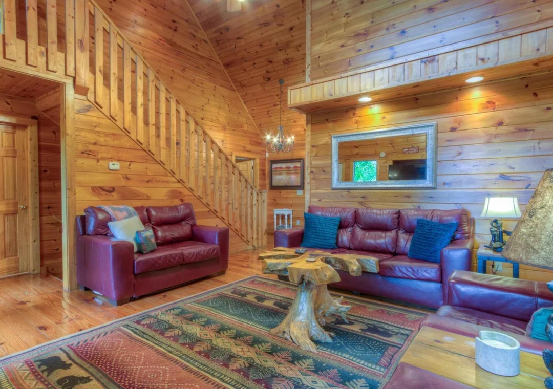 Sink into rich leather sofas beneath soaring wood ceilings, where rustic charm meets cozy comfort. Natural light filters through skylights, illuminating your peaceful mountain retreat.