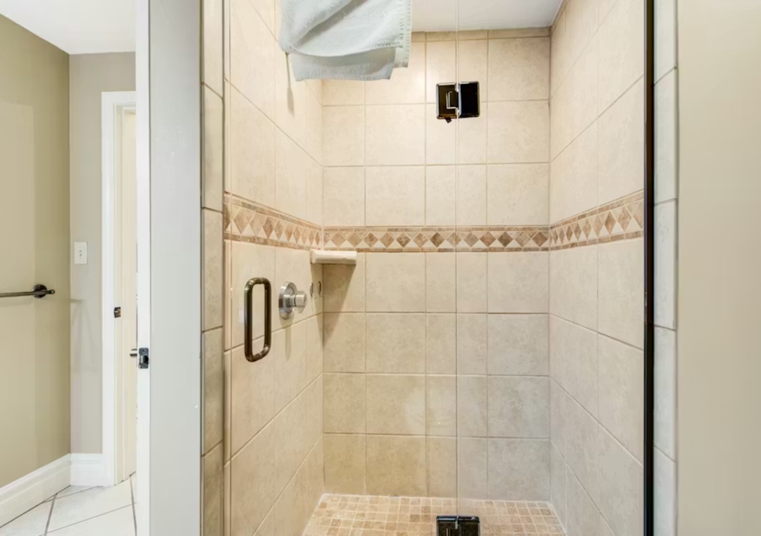 Step into your private spa-like shower with elegant tiled walls and decorative accents for a refreshing start to each day.