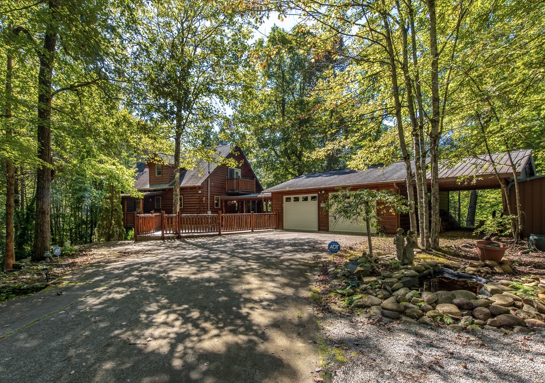 A warm log cabin nestled in the woods, surrounded by towering trees and dappled sunlight, offering a peaceful retreat into nature with convenient parking and secluded charm.