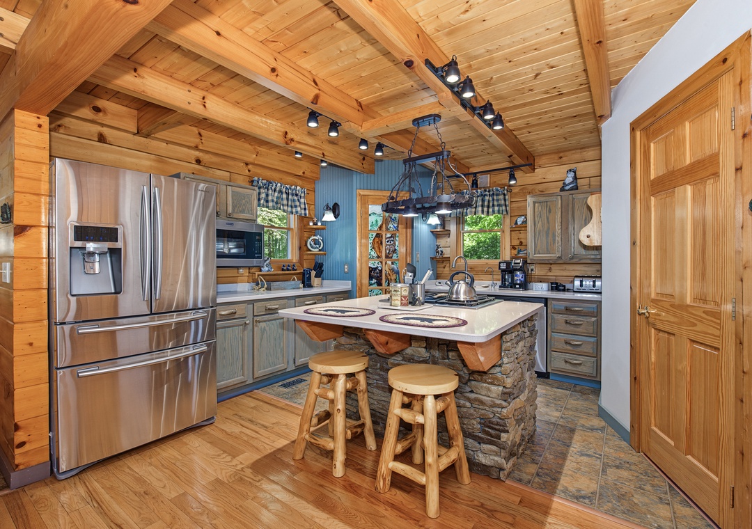 Your fully-equipped kitchen with soaring wood-beamed ceilings, stainless steel appliances, and a charming stone-accented island invites you to gather and cook in rustic mountain style.